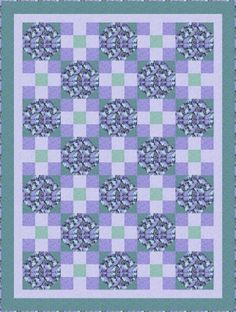 a blue and green quilt with an intricate design on the front, in shades of purple