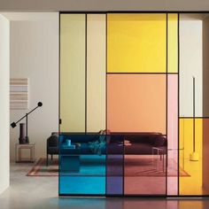 the room is filled with colorful furniture and glass partitions to divide it from the living area