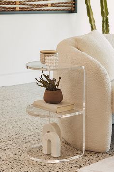 a living room with a couch, table and potted plant