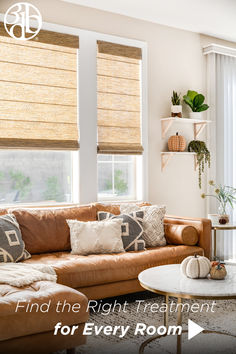 a living room filled with lots of furniture and windows covered in shades of light brown