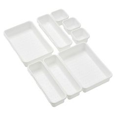 four white plastic trays with holes on the bottom and one is filled with compartments