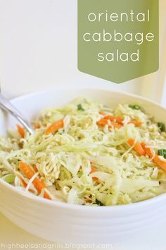 a white bowl filled with coleslaw and carrots next to a silver spoon