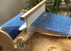 a close up of a weaving machine with blue yarn on the front and back sides