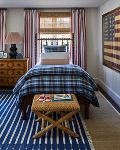 a bed room with a neatly made bed and striped rugs on the floor next to a window