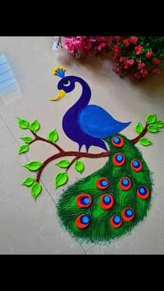 peacock sitting on top of a tree branch with green leaves and blue feathers painted on it