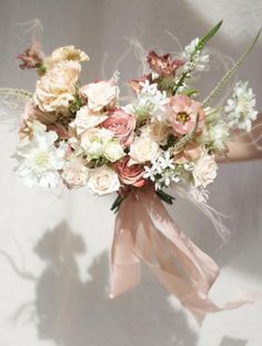 a bouquet of flowers is being held by someone's hand on a white background