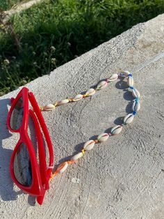 Rainbow cord with natural cowrie shell sunglasses chain, light and easy to wear. Length is 70 cm This sunglasses chain will add a summerish touch to your sunglasses or eyeglasses! Cowrie shells are natural so their size is not identical! Thanks for stopping by and don't forget to check my other listings too! Have a great day  Veronica Adjustable Chain Beach Jewelry, Handmade White Glasses Chains For The Beach, Handmade White Glasses Chains For Beach, Handmade White Glasses Chains For Summer, White Glasses Chains As Summer Gift, White Adjustable Glasses Chains For Summer, White Glasses Chains For Summer Gift, Trendy Shell-shaped Jewelry For The Beach, Handmade White Glasses Chains For Festival