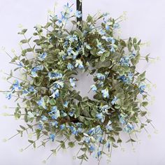 a wreath with blue flowers hanging on a wall