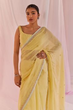 Yellow saree in silk chanderi base and with dori embroidery, sequin and pearl embellishments. Paired with a matching padded square neck silk chanderi sleeveless blouse.
Components: 2
Pattern: Embroidered
Type Of Work: Pearl, Sequin
Neckline: Square
Sleeve Type: Sleeveless
Fabric: Silk Chanderi, Lining: Shantoon
Color: Yellow
Other Details: 
Model Height: 5ft 6inches, wearing size M
Occasion: Puja, Mehendi and Haldi - Aza Fashions Dori Embroidery, Scalloped Blouse, Saree Blouses Online, Yellow Saree, Blouse For Women, Fashion Inspiration Design, Saree With Blouse, Fabric Silk, Blouse Online