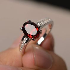 This is a gorgeous handmade creation. Its beauty is its simplicity & Elegance. The 7*9 mm oval shape faceted natural garnet is crafted in solid sterling silver and with rhodium plated. All item is sent in a beautiful gift box If you have any idea of design your ring,pls contact me directly. You can realize more lovely stuff clicking the link https://www.etsy.com/shop/knightjewelry?refshopsection_shophome_leftnav Please leave the correct address and you phone number for delivering successfull Gemstone Solitaire Ring, Pink Engagement Ring, Gemstone Engagement, January Birthstone, Red Gemstones