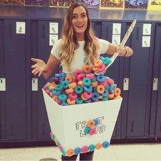 a woman standing in front of lockers holding a knife and box full of doughnuts