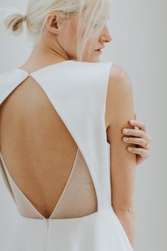 the back of a woman's dress with her hand on her shoulder and an open bra