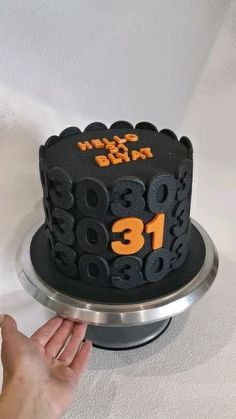 a cake with the number thirteen on it is being held by a person's hand