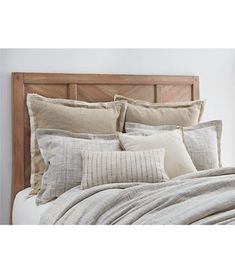 an image of a bed with pillows and blankets on it's headboard in the bedroom