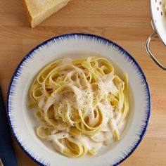 a plate of pasta with sauce and bread on the side