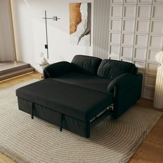 a black couch sitting on top of a rug in a living room