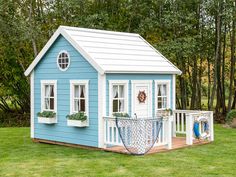 a small blue house with white trim and windows