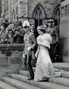 an old black and white photo of a man in uniform standing next to a woman