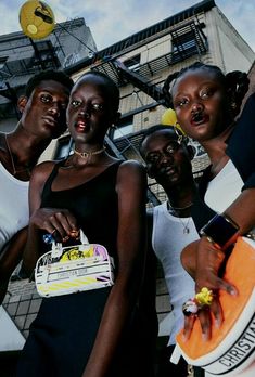 four women posing for the camera in front of a building