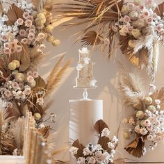 a wedding cake surrounded by flowers and feathers