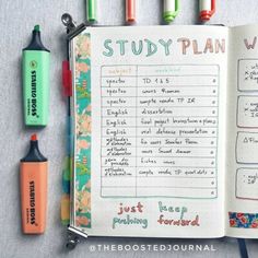 an open notebook with markers and pens on it