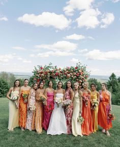 a group of women standing next to each other on top of a lush green field