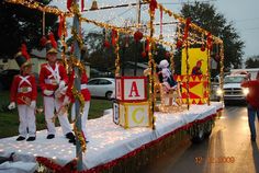 a parade float with people dressed in red and white outfits on the back of it