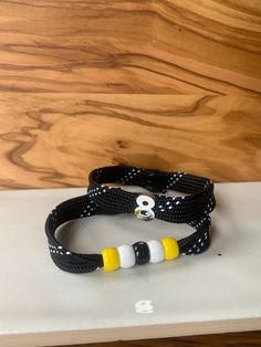 two black and white bracelets sitting on top of a laptop