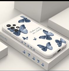 an iphone case with blue butterflies on it sitting in front of some white boxes,