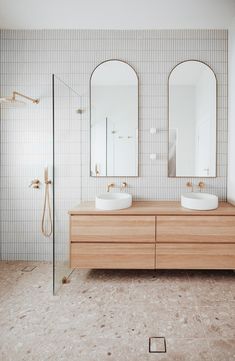 a bathroom with two sinks and mirrors on the wall