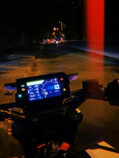 a motorcycle with a gps device on it's handlebars in the dark