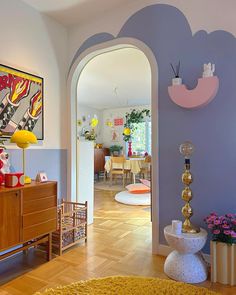 an archway leads to the dining room and living room in this modern style home with wood flooring