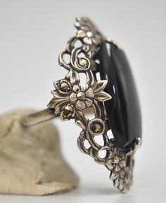 "Long onyx ring Art Deco Marcasites floral design sterling silver women **AS IS**Loose stone & Bent Band Not structural Size 4.25 Weight 6.2g Widest part of band 1 3/8\" Thinnest part of band 1/8\" Delivered in a Gift Box Free Shipping and Free Postal Insurance" Antique Oval Flower Ring For Formal Occasions, Vintage Silver Onyx Jewelry, Vintage Onyx Gemstone Jewelry, Vintage Onyx Ring Jewelry, Ornate Cabochon Rings For Anniversary, Victorian Sterling Silver Rings With Cabochon, Collectible Onyx Ring Jewelry, Ornate Collectible Ring Jewelry, Collectible Ornate Ring