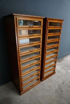 two wooden shelves sitting next to each other on the floor in front of a blue wall