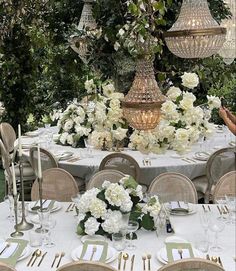 the table is set with white flowers and place settings for an elegant dinner or party