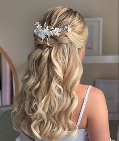 a woman with long blonde hair wearing a white flowered headpiece in her hair