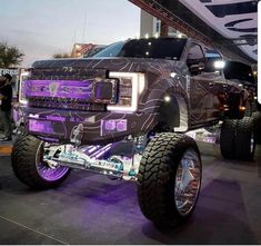 a large truck with purple lights on it's front bumpers and big tires