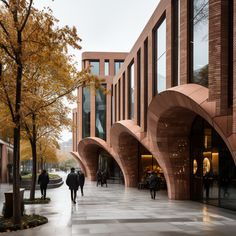 two people walking down the sidewalk in front of a building with arches on both sides