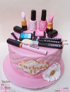 a pink cake with makeup and cosmetics on it