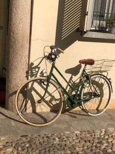 a green bike parked next to a building