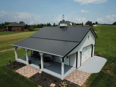 a large white barn with a black roof