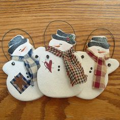 three snowmen with hats and scarfs on their heads