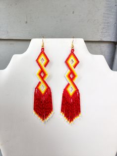 These Twisted Earrings made by Elaine, with  Red, Orange, Yellow and White Delica Beads with long red silver lined twisted bugles. They are about  4 in. long with Gold wires on them, can be changed to post or clips. If you like them but would like other colors just let me know. I do Spiecal orders. If you have any Questions just ask. Made to Order. "It can take up to a week to make, but well worth the wait."  Thanks for looking. Adjustable Red Beaded Fringe Earrings, Adjustable Red Handwoven Earrings, Traditional Red Beaded Earrings With Large Beads, Red Bohemian Beaded Earrings, Traditional Red Beaded Fringe Jewelry, Red Handwoven Beads For Jewelry Making, Red Bohemian Dangling Beads, Artisan Red Beaded Earrings With Dangling Beads, Southwestern Red Beaded Earrings With Dangling Beads