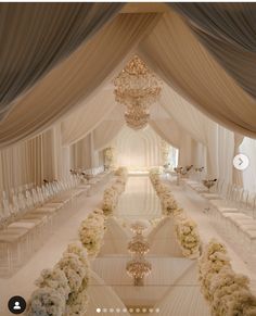 an image of a wedding setup with white flowers and chandeliers on the ceiling