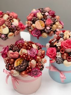 three small blue boxes filled with lots of different types of candies and flowers on top of each other