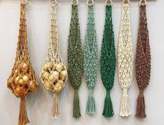 several tassels are hanging on the wall with gold balls in them and green cords