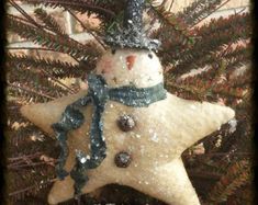 a snowman ornament hanging from a christmas tree