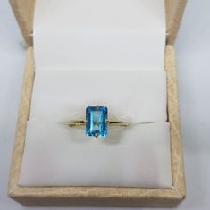 14k solid yellow gold natural emerald cut rectangular shaped blue topaz semi precious gemstone ring. 1. The weight of natural blue topaz gemstone used in the ring =1.40 cts. 2. The weight of 14k solid yellow gold used in the ring =1.150 grms. 3. The topaz is the birthstone for the people born in the month of November. 4. The design of the ring is very nice and beautiful. 5. I have used all my skills and experience to manufacture this ring as beautiful as I can and I do hope that my work will be Modern 14k Gold Emerald Cut Topaz Ring, Yellow Gold Blue Topaz Baguette Cut Ring, Yellow Gold Baguette Cut Blue Topaz Ring, Blue Topaz Baguette Cut Ring In Yellow Gold, Baguette Cut Blue Topaz Ring In Yellow Gold, Fine Jewelry Topaz Ring With Rectangular Accent Stones, Fine Jewelry Topaz Promise Ring With Rectangular Stone, Gift Topaz Ring With Prong Setting And Rectangular Stone, Fine Jewelry Topaz Ring With Rectangular Stone For Promise