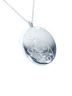 "The beautiful Sterling Silver Oval locket by Silverspirit  jewellery is a uniquely designed piece of jewellery. Featuring a Oval design this Locket has a engraving on  Left with a Clear Silver Finish on the right Corner ,Created by  sterling silver and finished with an anti-tarnish polish. This Locket comes with a Sterling Silver 18\" Chain. The chain can be changed to any size 16\" to 26\" whatever is required at no charge." Elegant White Gold Oval Link Locket Necklace, Elegant Engraved Locket Necklace With Oval Link, Elegant Oval Pendant Locket Necklace For Memorials, Elegant Oval Pendant Locket Necklace For Memorial, Oval Locket Necklace With Intricate Design For Anniversary, Elegant Oval Necklaces With Engraving Option, Elegant Oval Pendant Keepsake Jewelry, Elegant Oval Jewelry For Keepsake, Elegant Customizable Oval Pendant