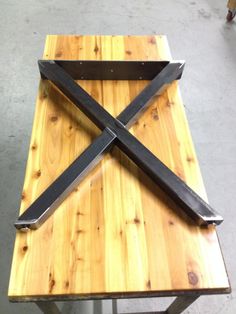 a wooden table topped with two large black knives on it's sides and a knife holder in the middle